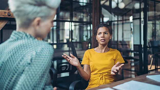 employee conflict resolution photo showing boss with employee talking one-on-one